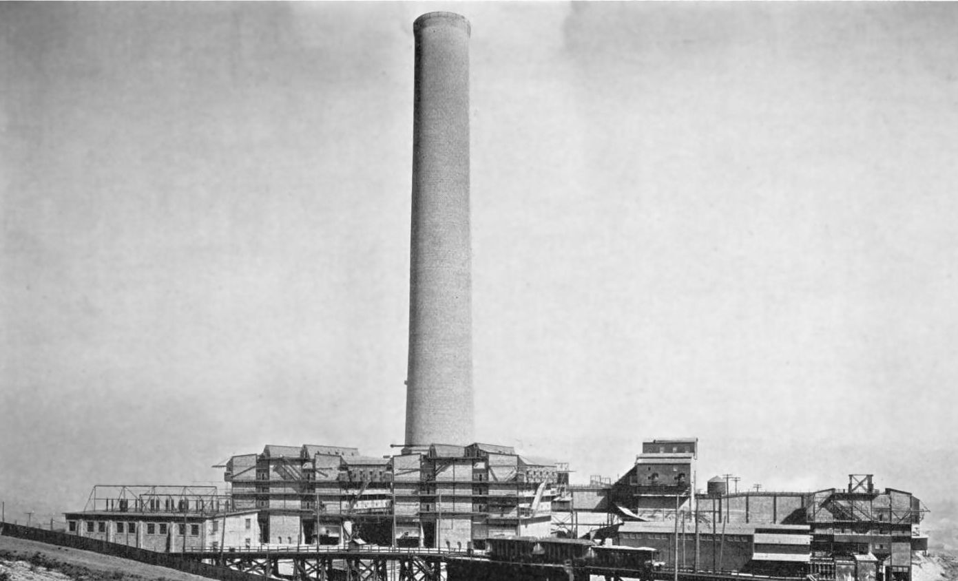 The new stack towering over the long rows of the electrical dust treater buildings, 1920