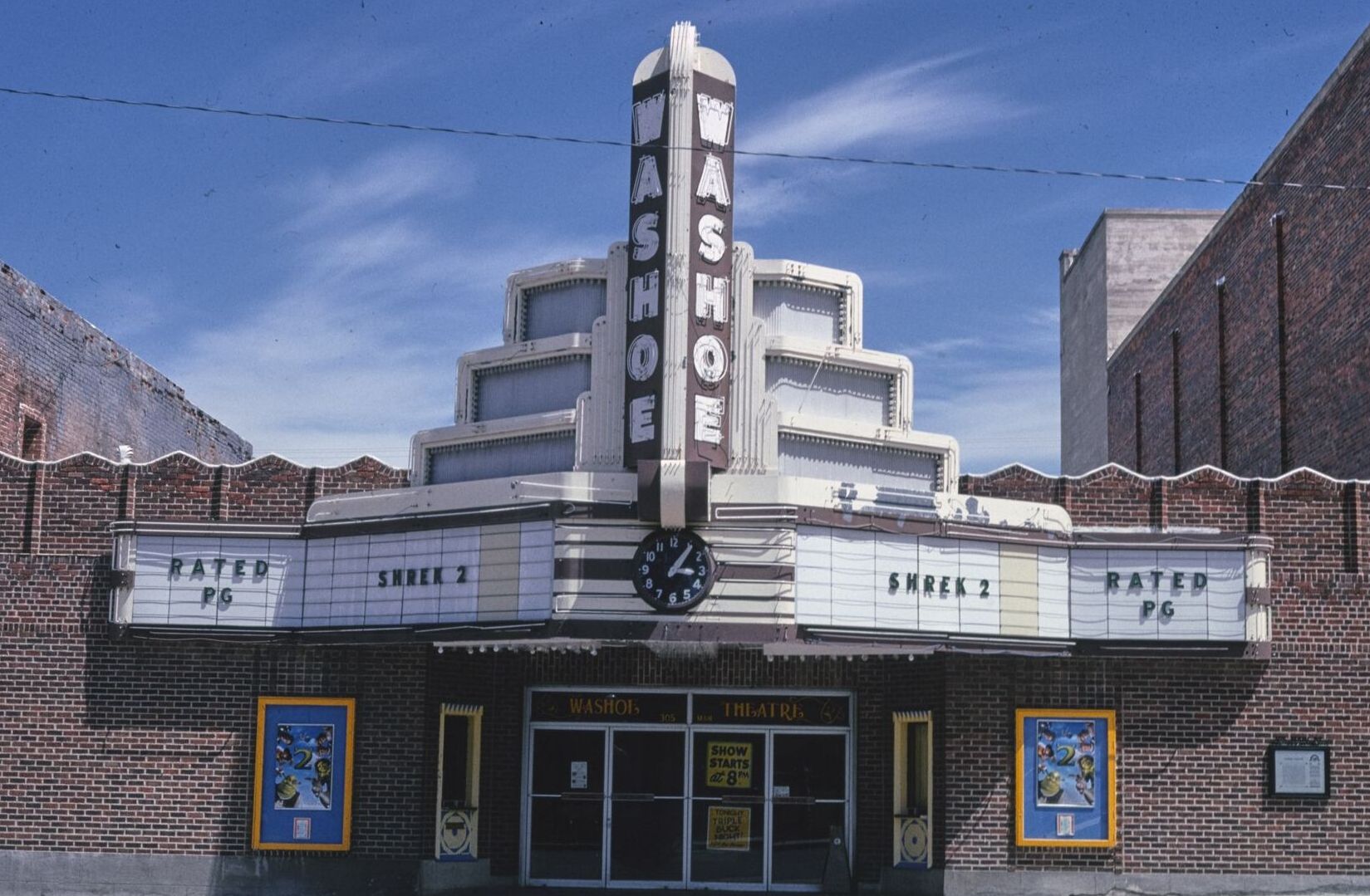 The stepped neon tower and marquee of the Washoe Theater against a blue sky